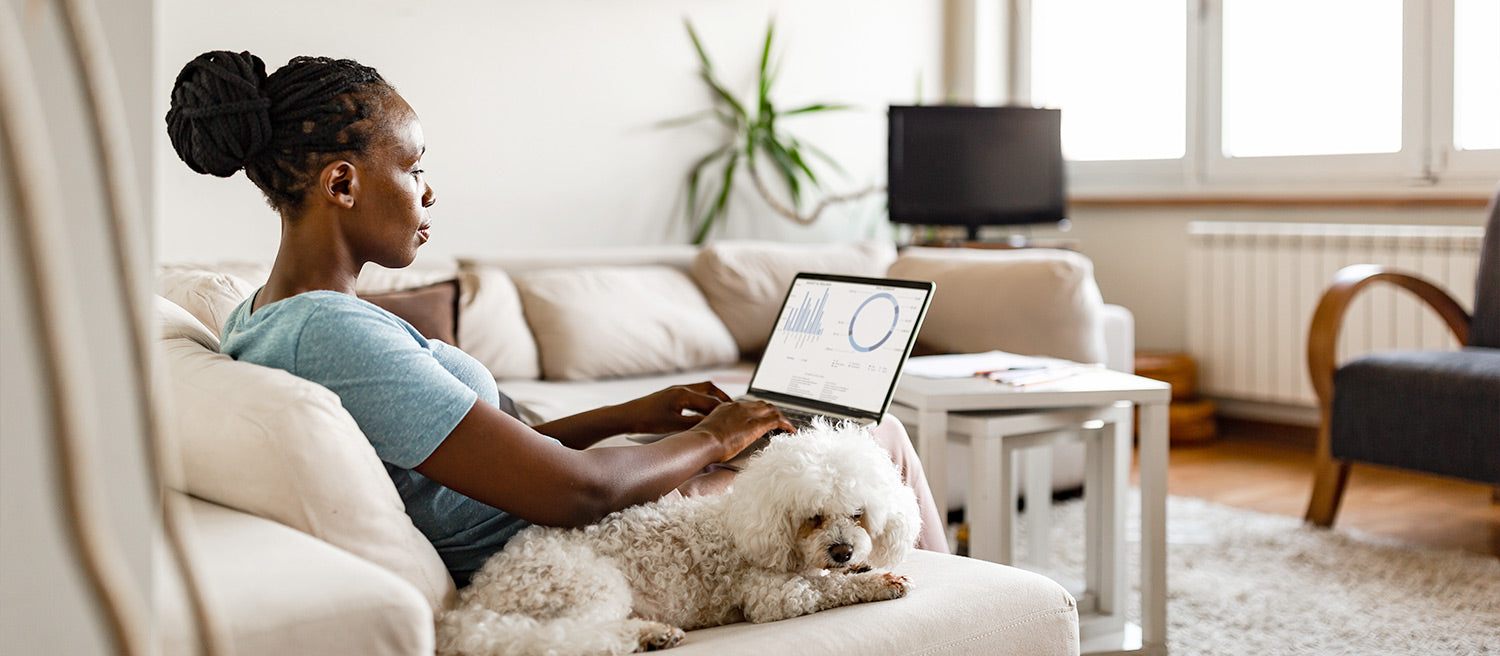 Women sitting on beige couch taking advantage of working from home commute time